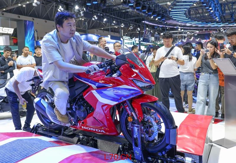 去年9月,观众在重庆摩博会现场体验摩托车模拟驾驶。新华社